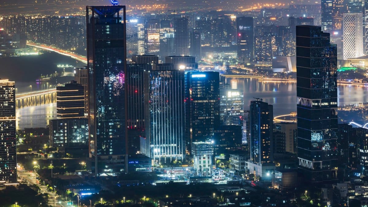Vibrant city skyline at night showcasing illuminated skyscrapers and bustling city lights.