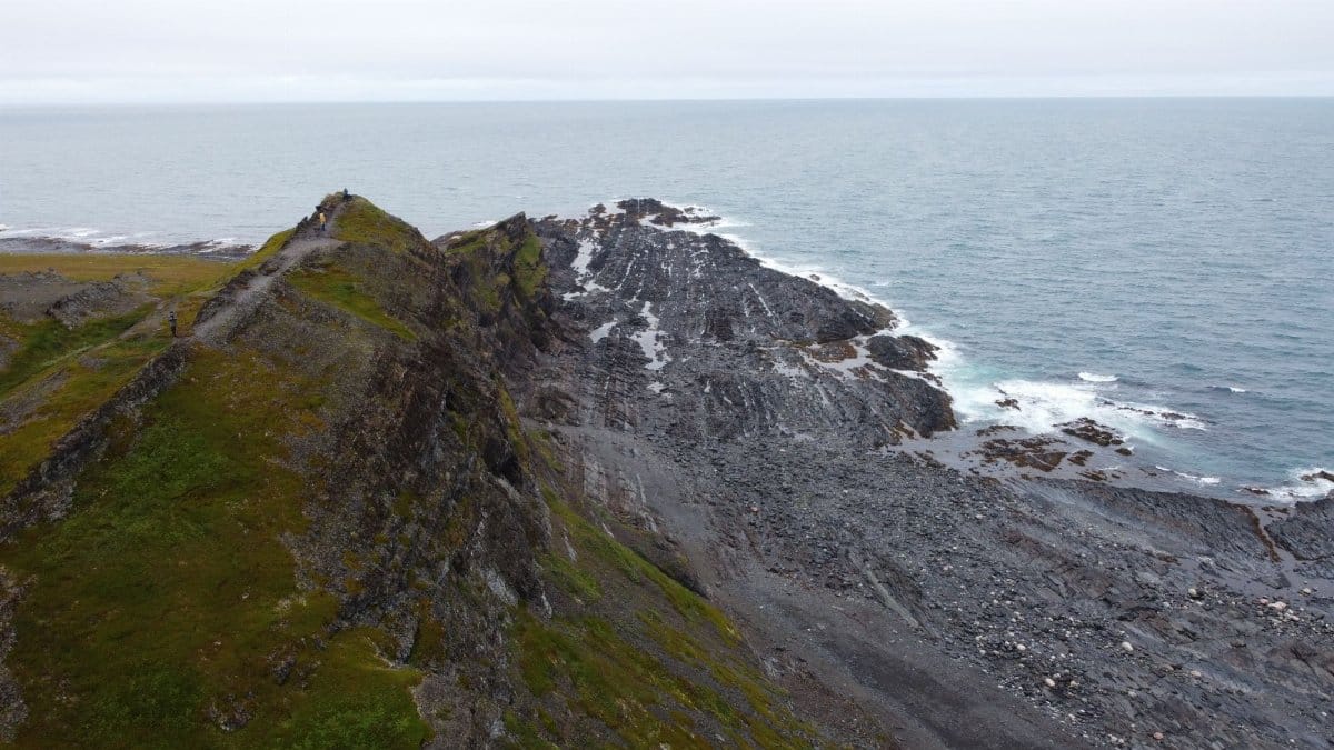 Stunning aerial view of Vayda-Guba's rocky coastline and ocean under an overcast sky.