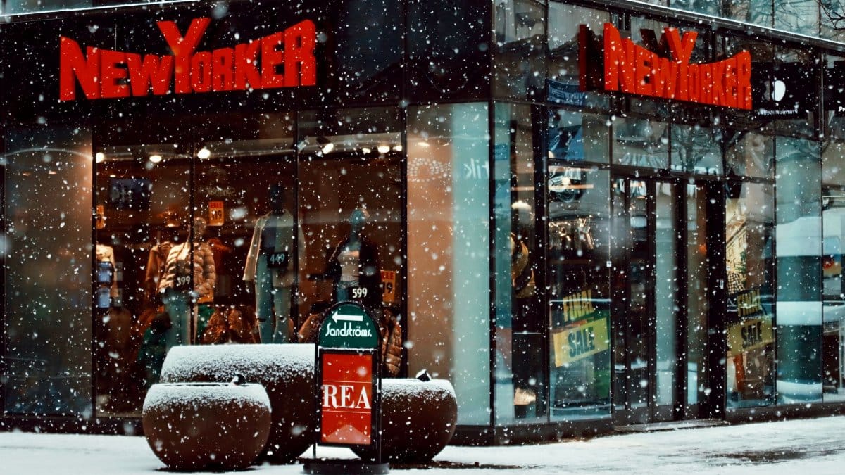 Snowfall at a bustling New Yorker store in Jönköping, Sweden, during winter.