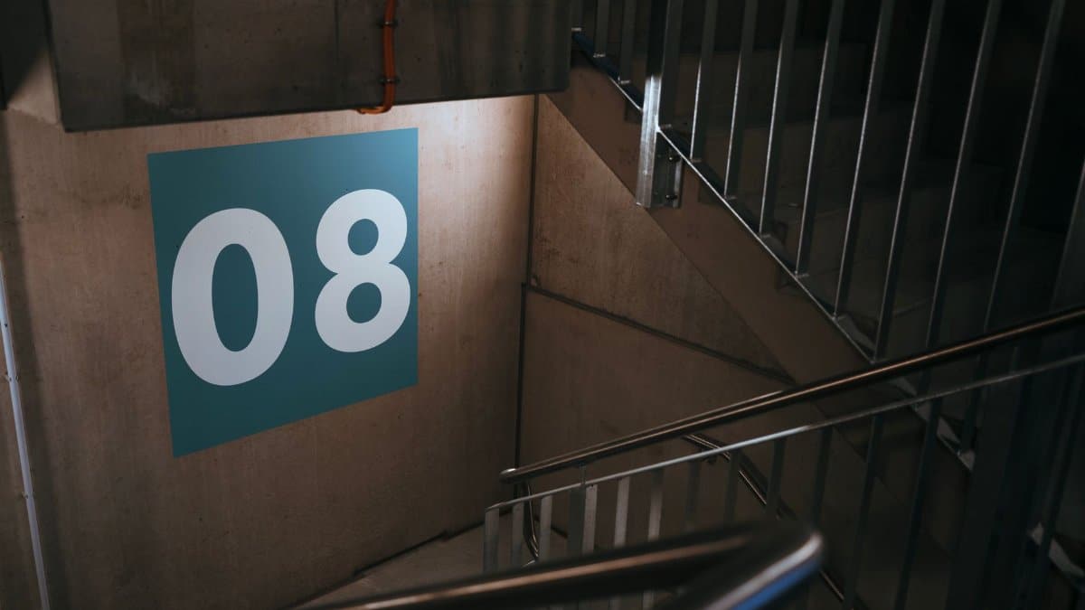 Industrial stairwell featuring a large number eight sign on the wall.