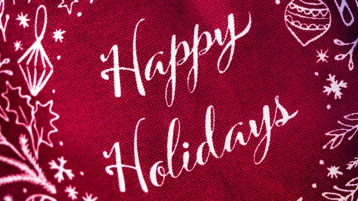 Bright red fabric with white 'Happy Holidays' and festive decorations for a cheerful holiday vibe.