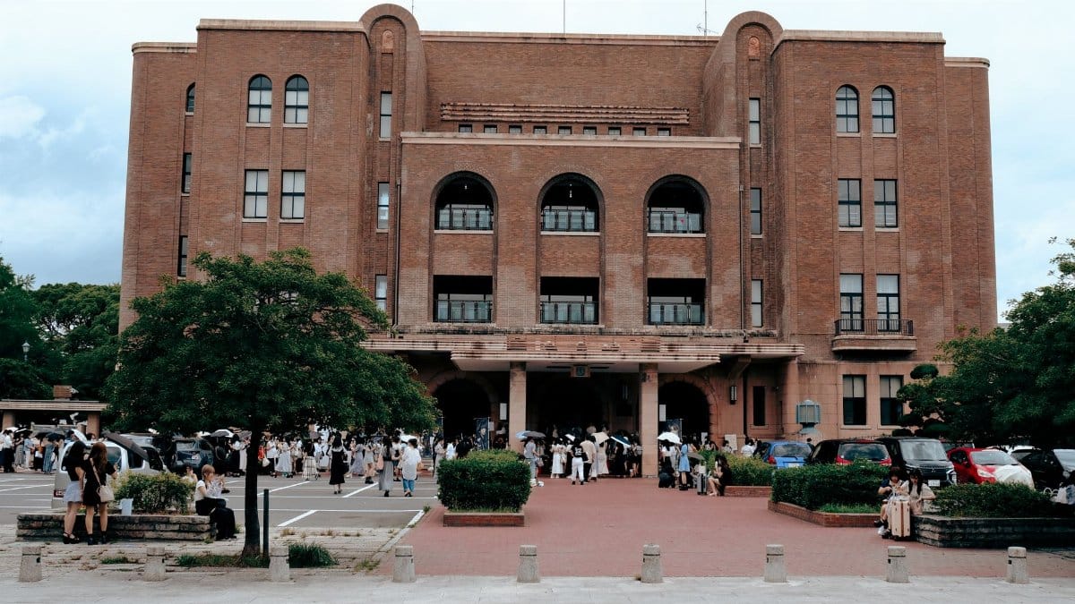 Exterior view of Nagoya Civic Assembly Hall with people gathering outside on a bright day.