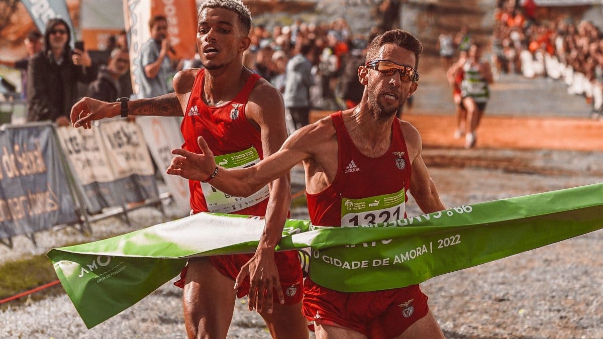 Two male athletes cross the finish line at a marathon, capturing the intense competition.