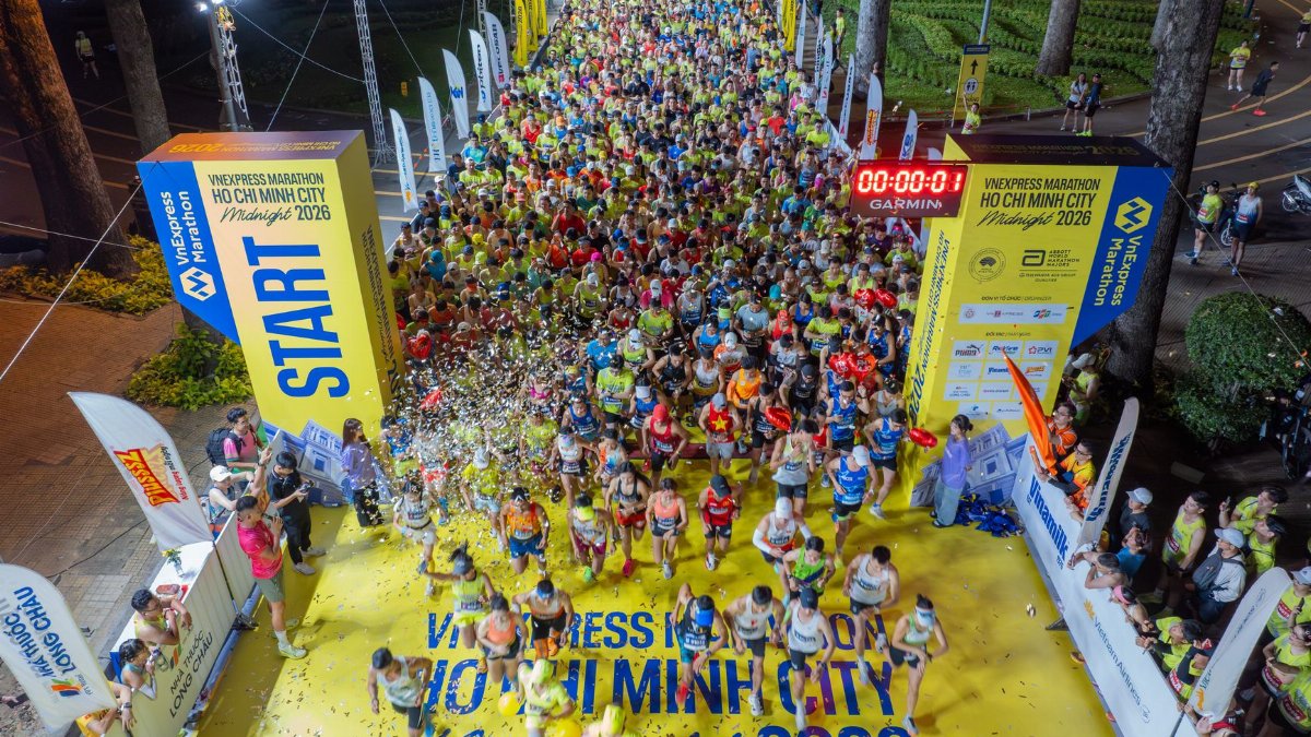 Vivid start of a midnight marathon in Ho Chi Minh City with a large crowd.