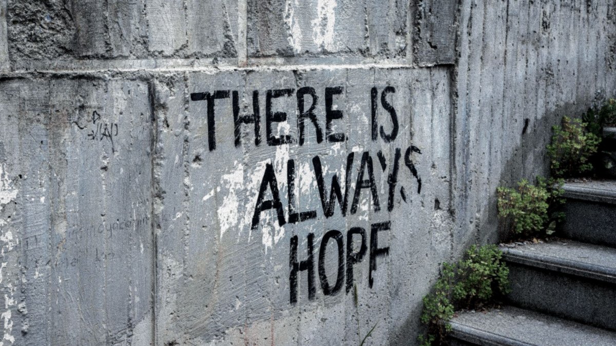 Graffiti on concrete wall reads 'There is always hope' next to outdoor stairs.