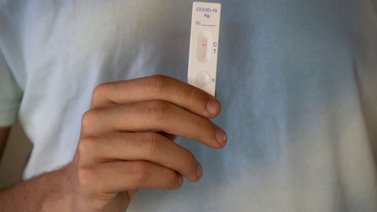 Close-up of a negative COVID-19 test result being held by an adult's hand, symbolizing hope and health.