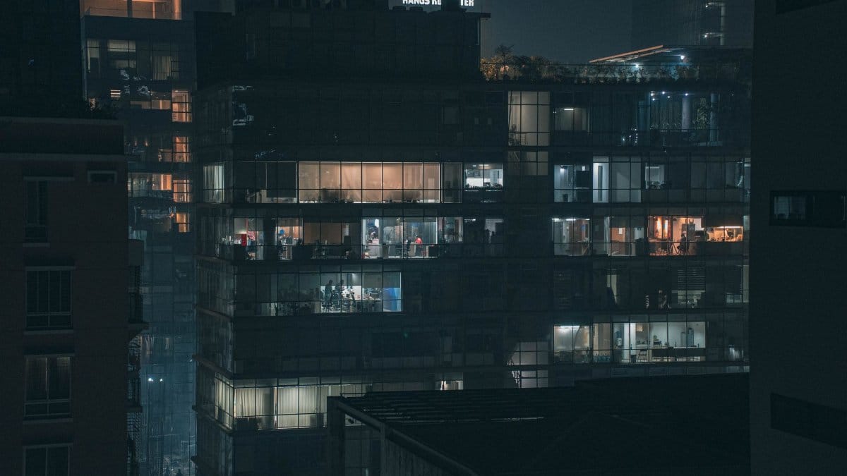 Illuminated office building in Dhaka's cityscape, showcasing modern architecture at night.