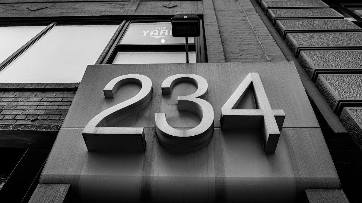 Monochrome view of a building facade showcasing a large 234 address number.