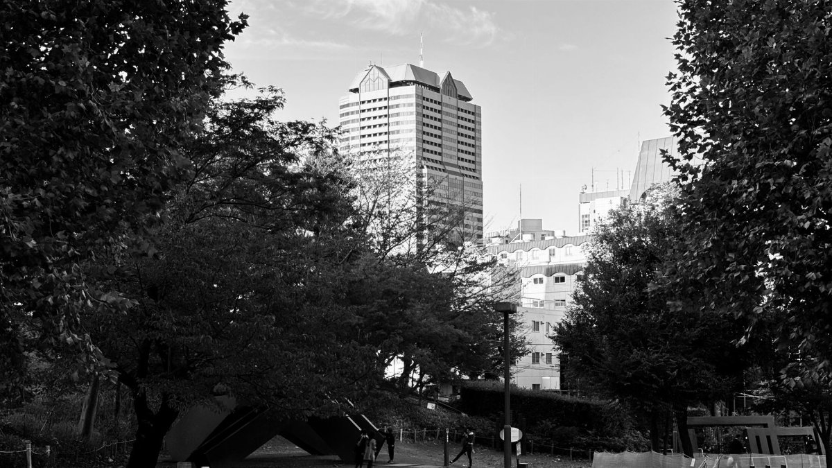 Black and white view of Tokyo cityscape with park and modern architecture.