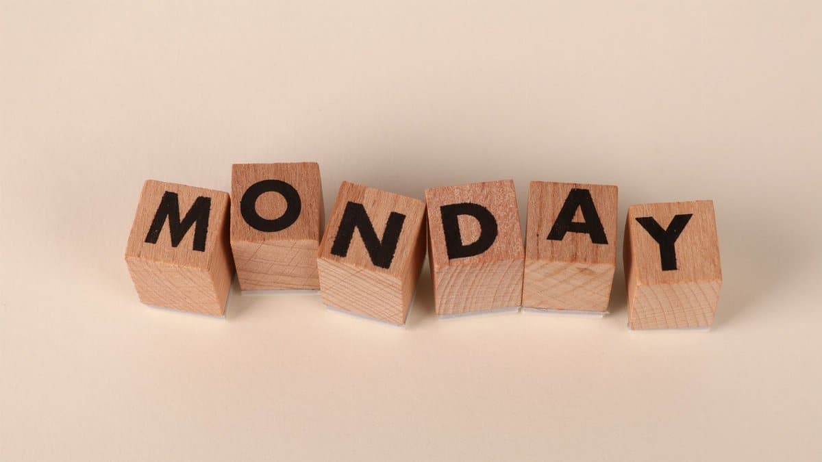 Wooden blocks spelling Monday on a neutral background, symbolic of the start of the week.