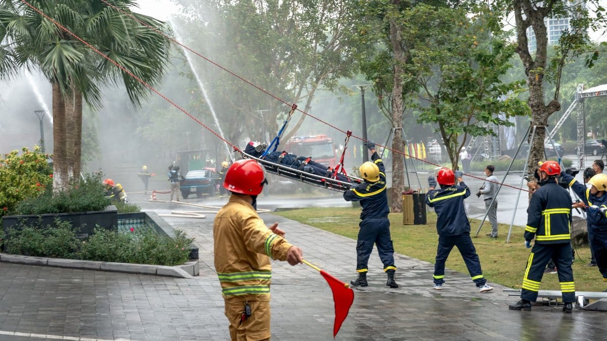 Firefighters performing a high angle rescue operation in an urban setting, demonstrating teamwork and emergency skills.