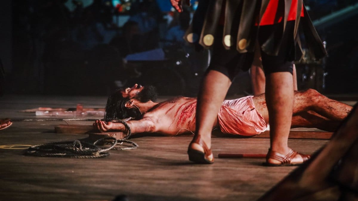 Emotional depiction of a religious play scene with actors performing a crucifixion.