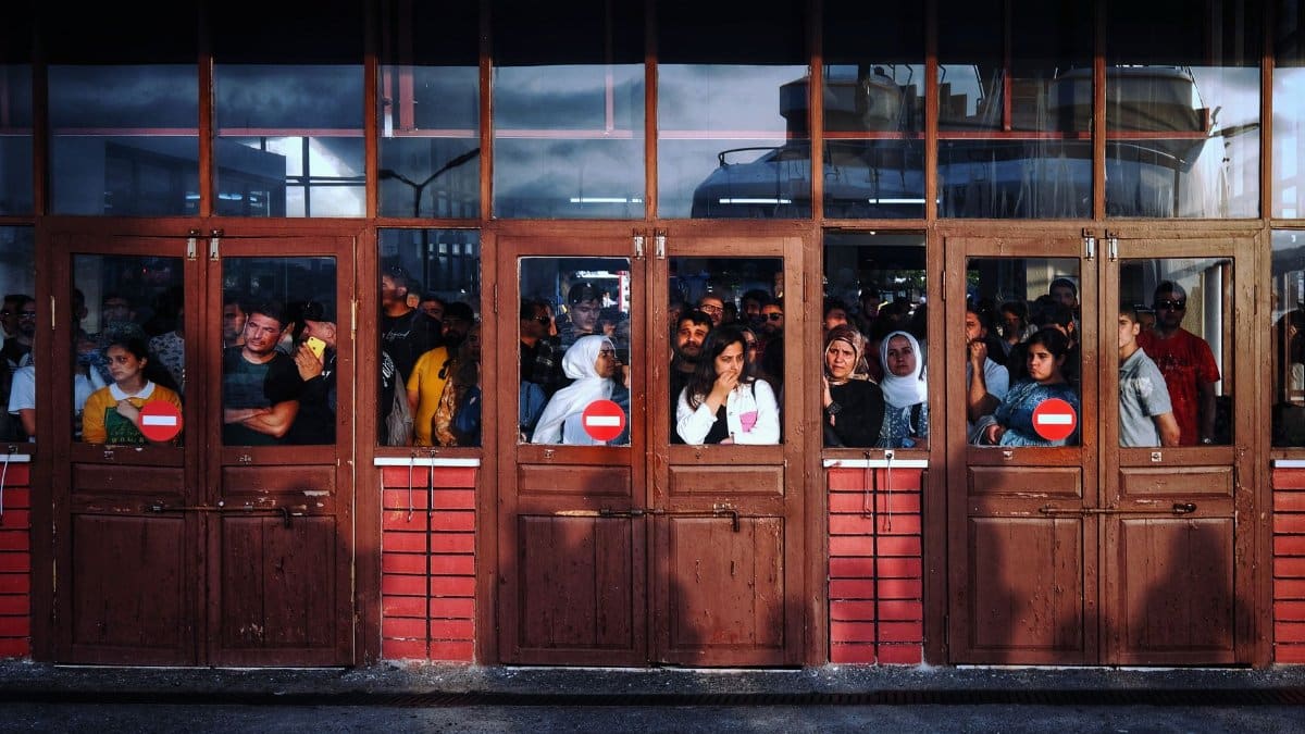 A bustling scene of people waiting inside a terminal entrance in İstanbul, Turkey.