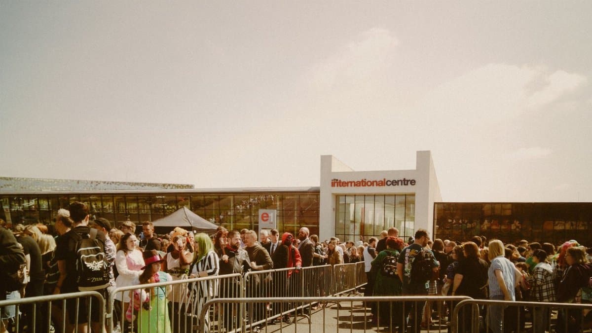 Large crowd gathering outside the International Centre under sunny skies.