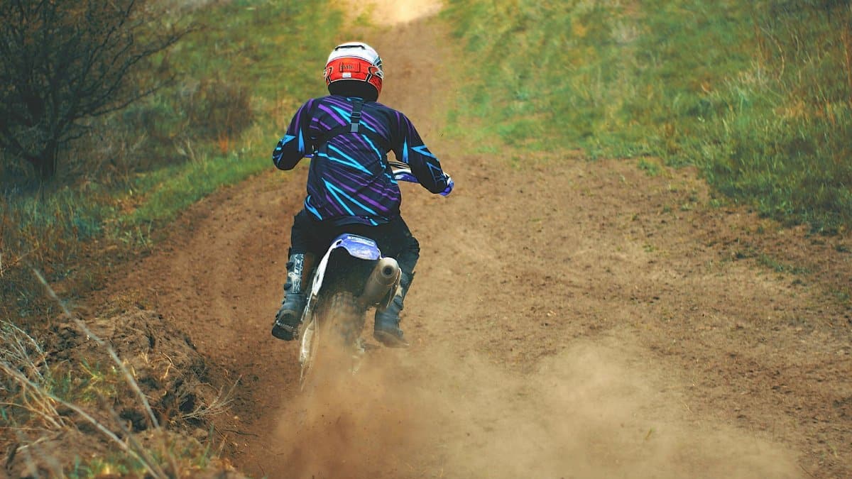 A motocross rider speeding down a dirt trail, showcasing action and adventure.