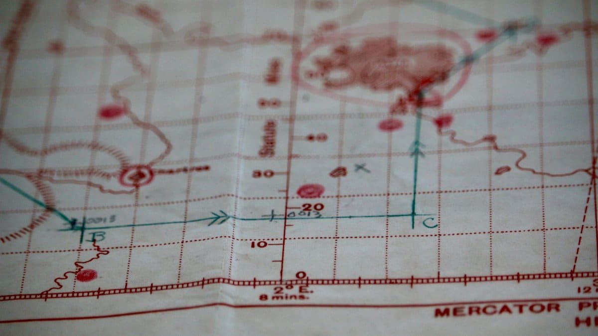 Detailed close-up of a vintage nautical map with visible coordinates and navigation markings.