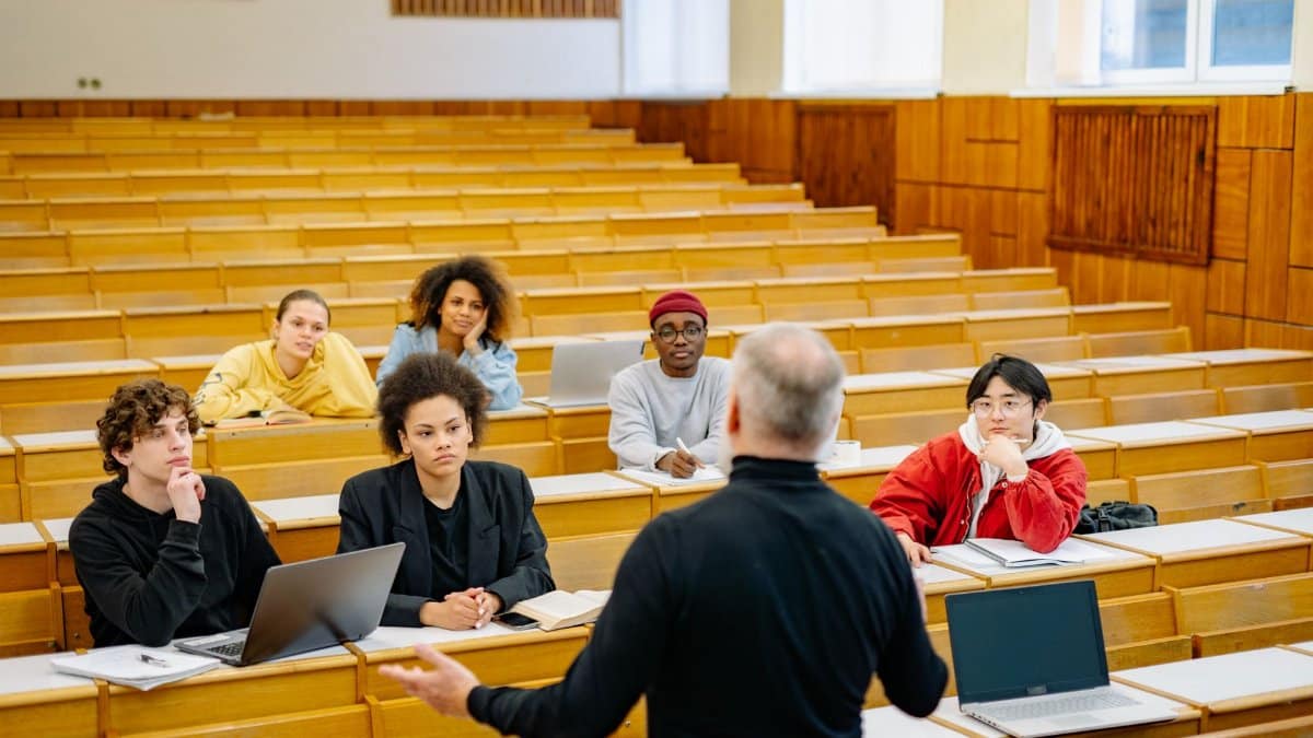 Professor teaching a diverse group of students in a university lecture hall.