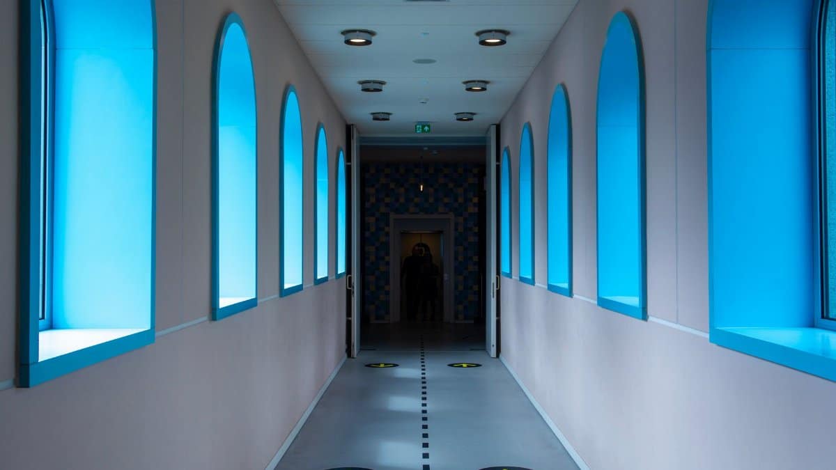 A contemporary corridor with blue arched windows and directional floor markings for a stylish modern look.