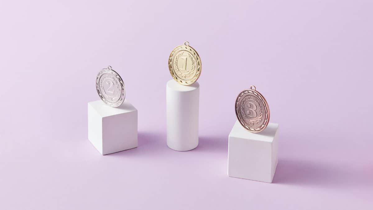 Three medals on podium blocks symbolizing first, second, and third place awards.