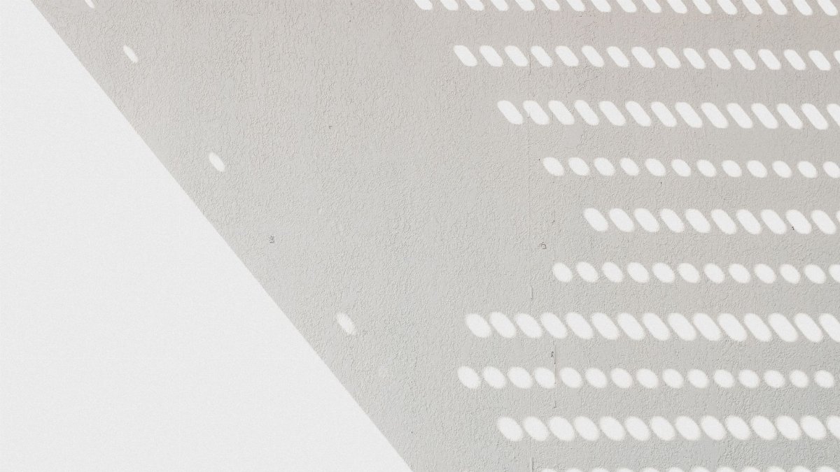 Abstract pattern of light and shadow on a textured wall surface.