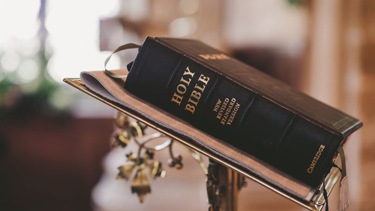 Holy Bible open on a stand inside a church, symbolizing faith and spirituality.