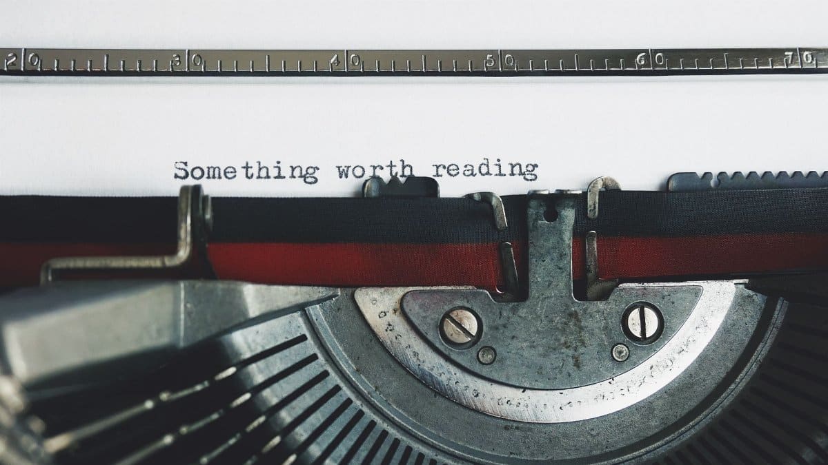 Close-up of a vintage typewriter with the phrase 'Something worth reading'.