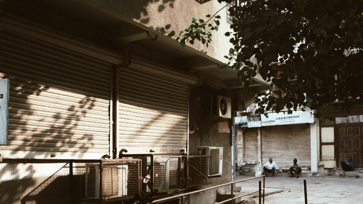 A quiet urban street scene with closed shops and visible air conditioners, capturing a tranquil city moment.