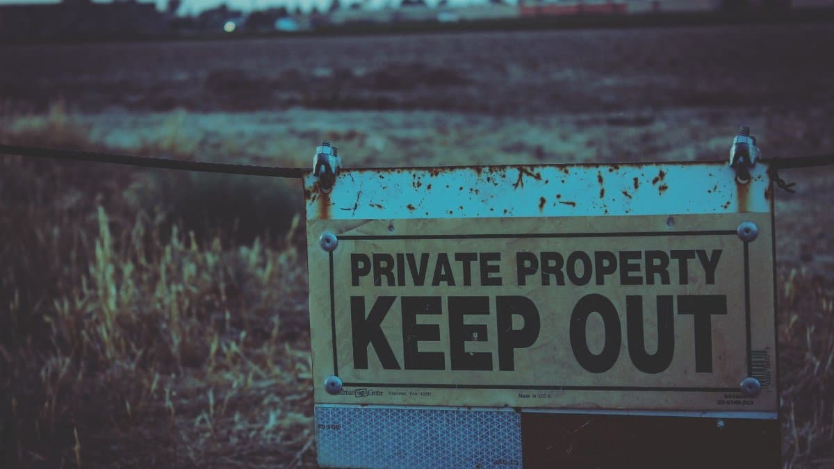 Private property sign with keep out warning in Atwater, California field.