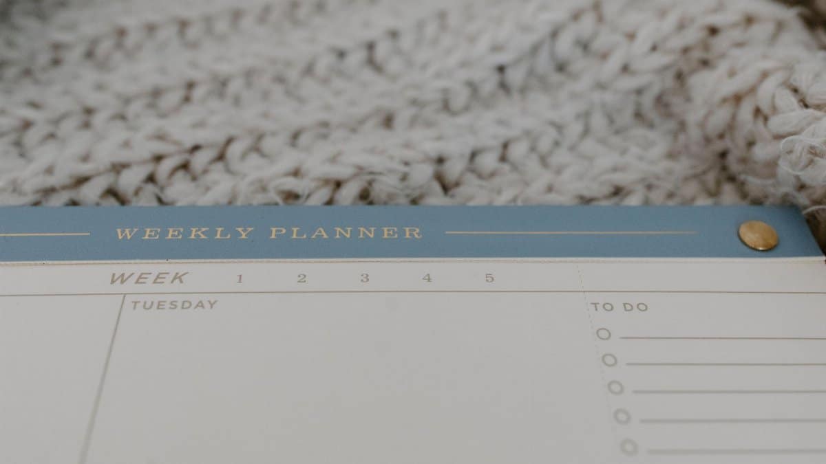 Close-up of a minimalist weekly planner on a cozy textured surface, perfect for organizing tasks.
