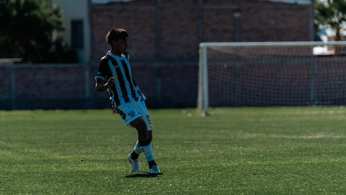 Young male soccer player mid-action on an outdoor field during a match.