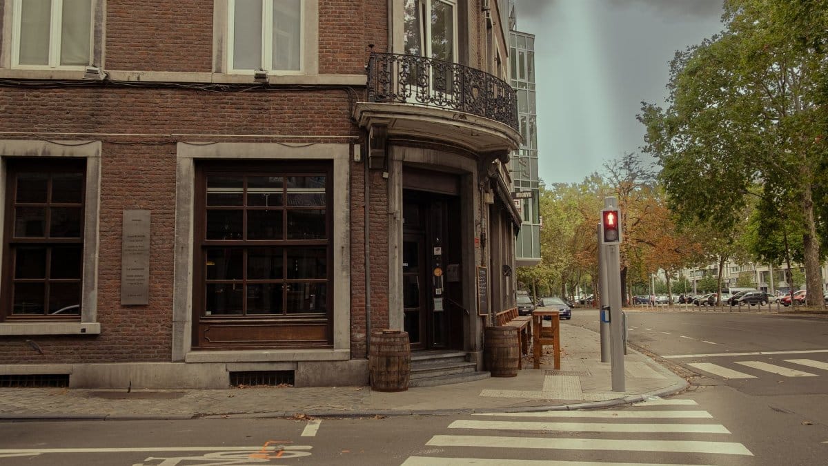Charming urban street corner with historic architecture and red traffic light at daytime.