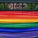 A vibrant city bridge adorned with rainbow fabric symbolizing diversity and pride.