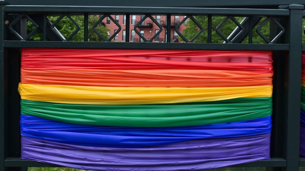 A vibrant city bridge adorned with rainbow fabric symbolizing diversity and pride.