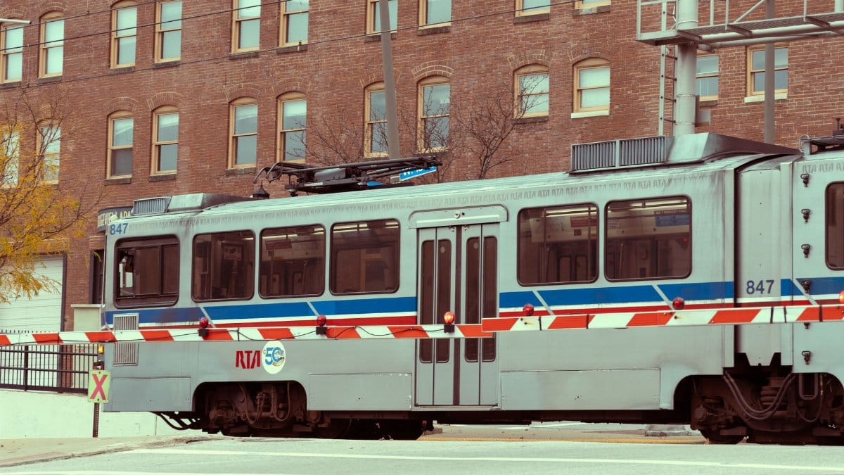 A light rail transit passing through an urban cityscape with brick buildings.