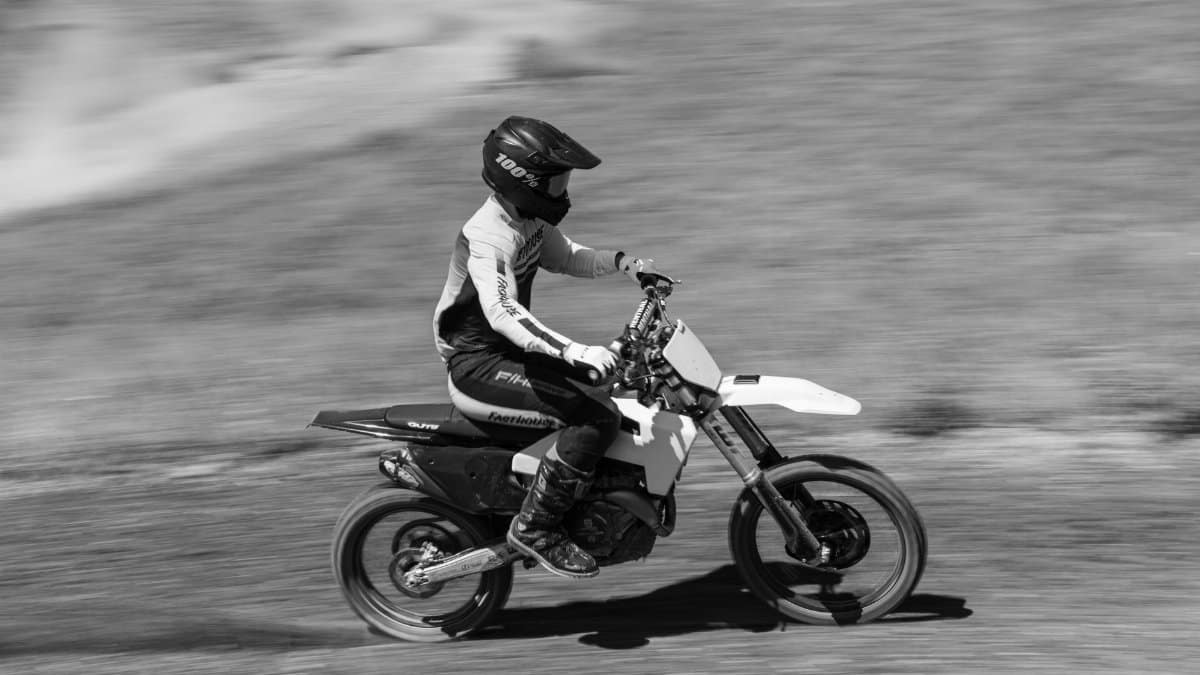 Dynamic black and white photo of a motocross rider racing on a dirt track in Pennsylvania.