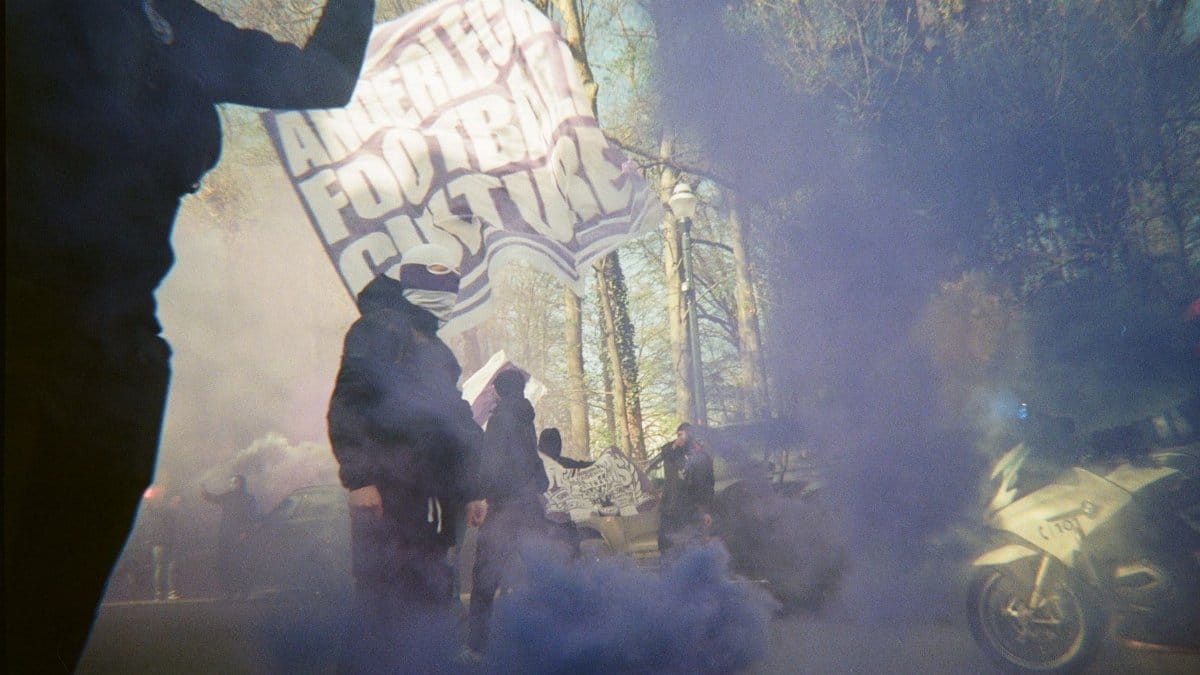 Protesters with banners and smoke on a street, creating a dynamic atmosphere.