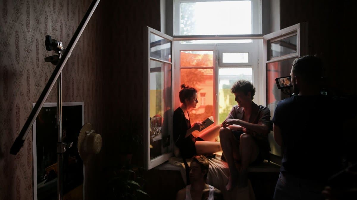 A behind-the-scenes look at a creative film shoot with models in natural light.