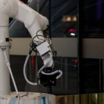 A white robotic arm operating indoors with a modern design and advanced technology.