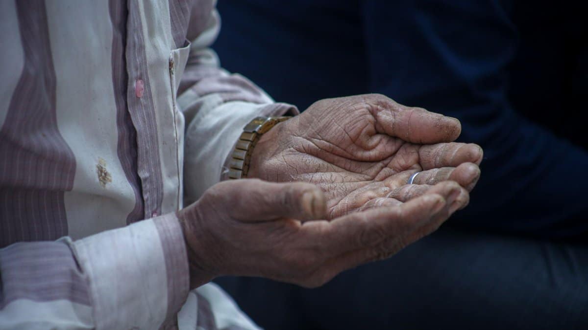 Close-up of elderly hands cupped together in a contemplative pose, evoking emotions.