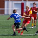 Energetic rugby scene with teenage players competing in a match outdoors.