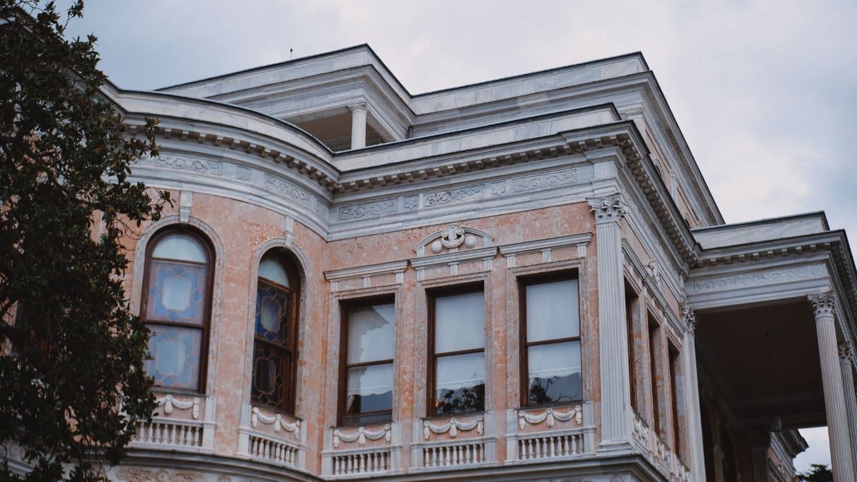 Close-up of an elegant vintage mansion with intricate architectural details and large windows.