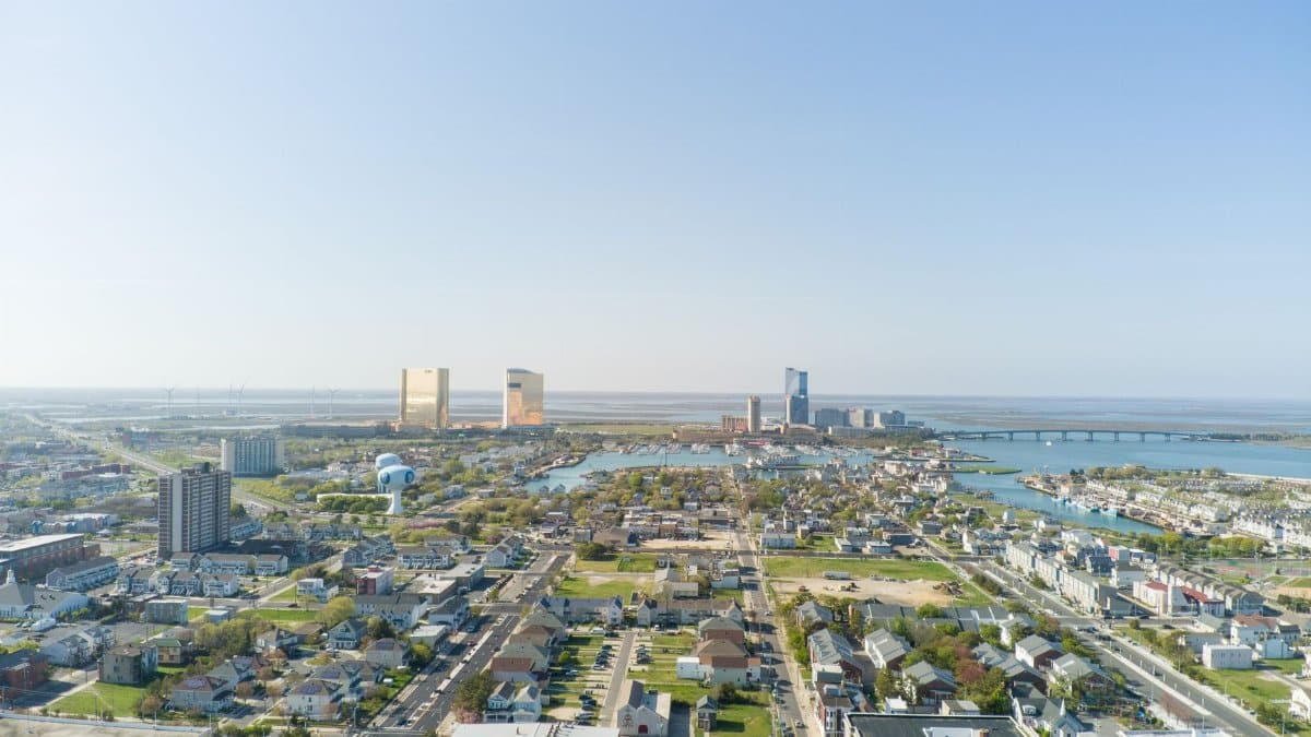 A vibrant aerial shot of Atlantic City, showcasing its bustling cityscape and coastline under clear skies.