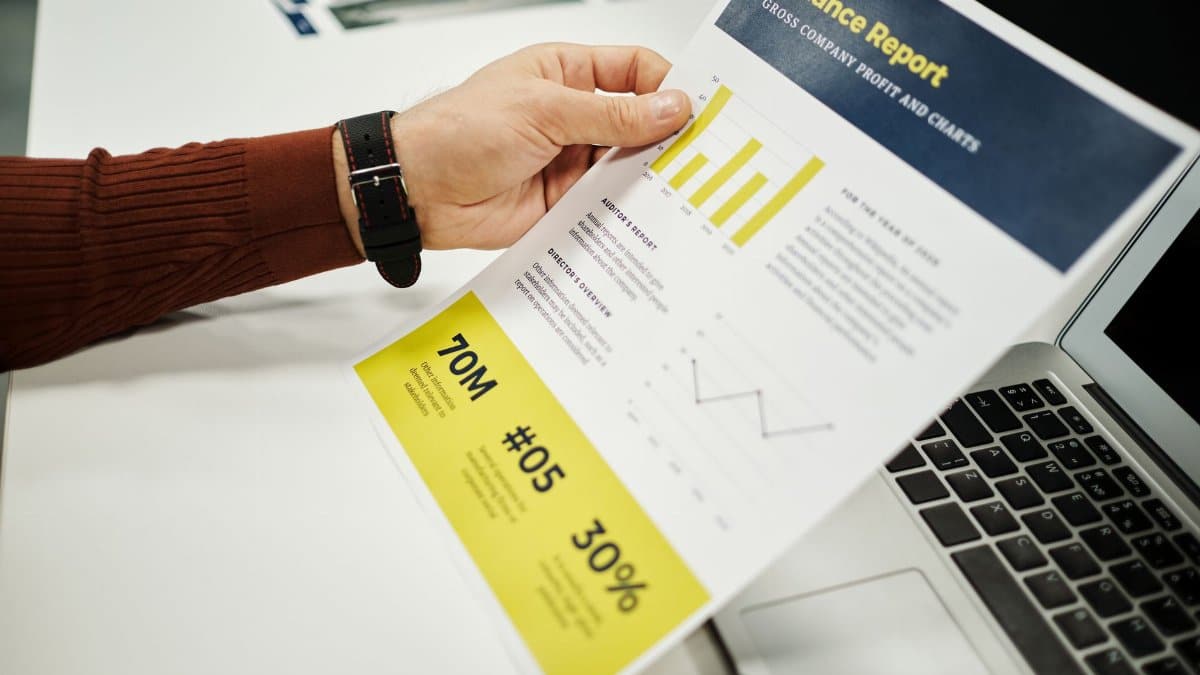 Person analyzing finance report with graphs at desk, ideal for business concepts.