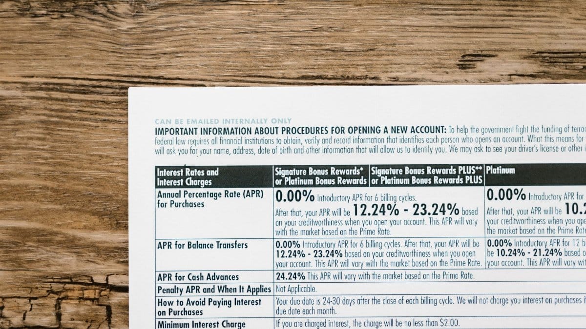 A detailed financial document listing interest rates on a textured wooden table.