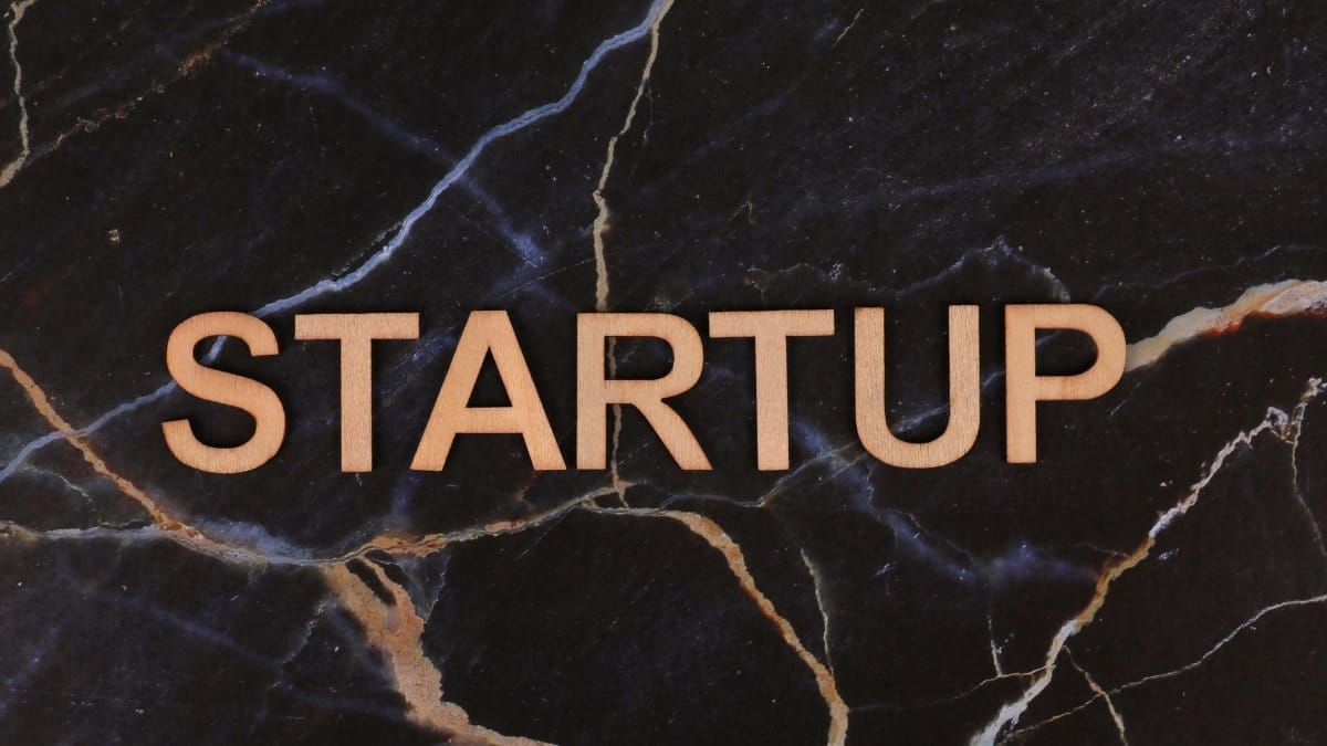 Wooden letters spelling 'STARTUP' on a dark marble background, symbolizing business innovation.