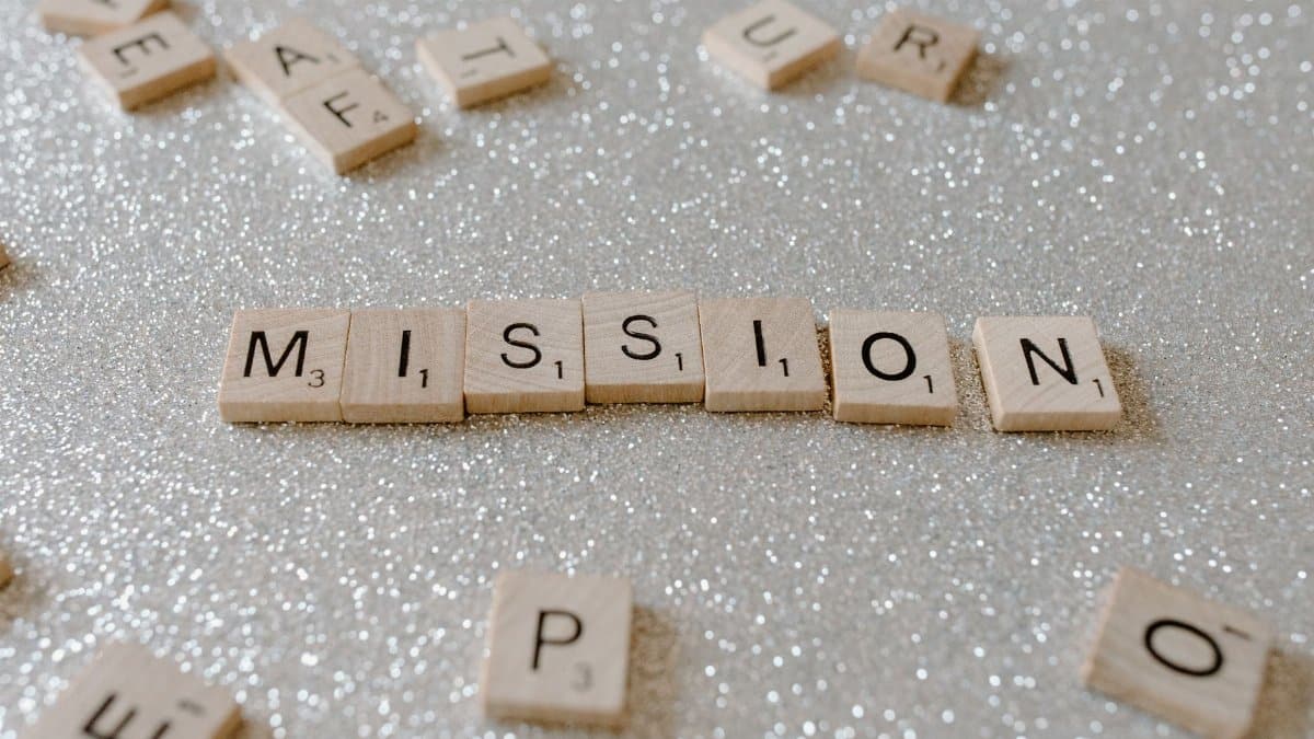 Scrabble tiles spelling 'Mission' on a sparkling surface convey determination and goals.