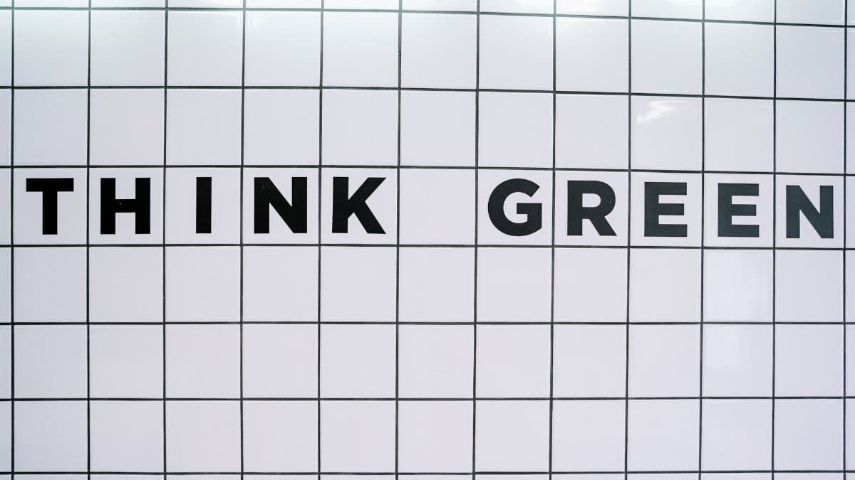 Modern wall art featuring the inspiring text 'Think Green' on a tiled background.