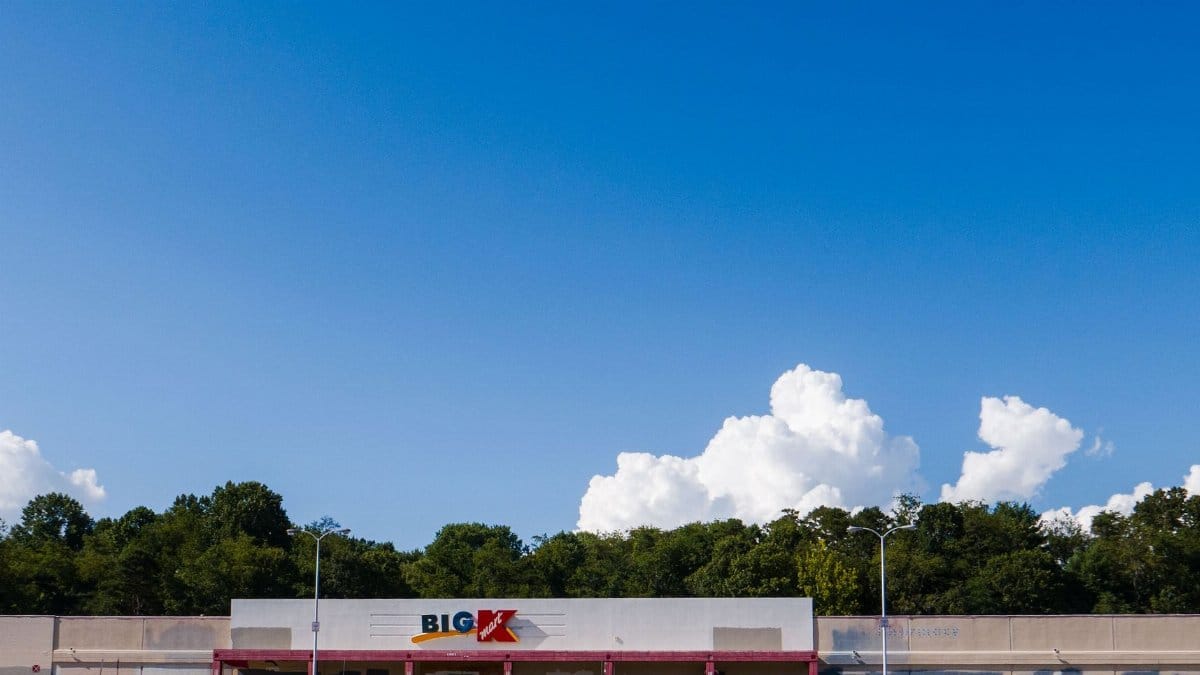 Abandoned Big K-Mart with clear blue sky backdrop, highlighting urban decay.