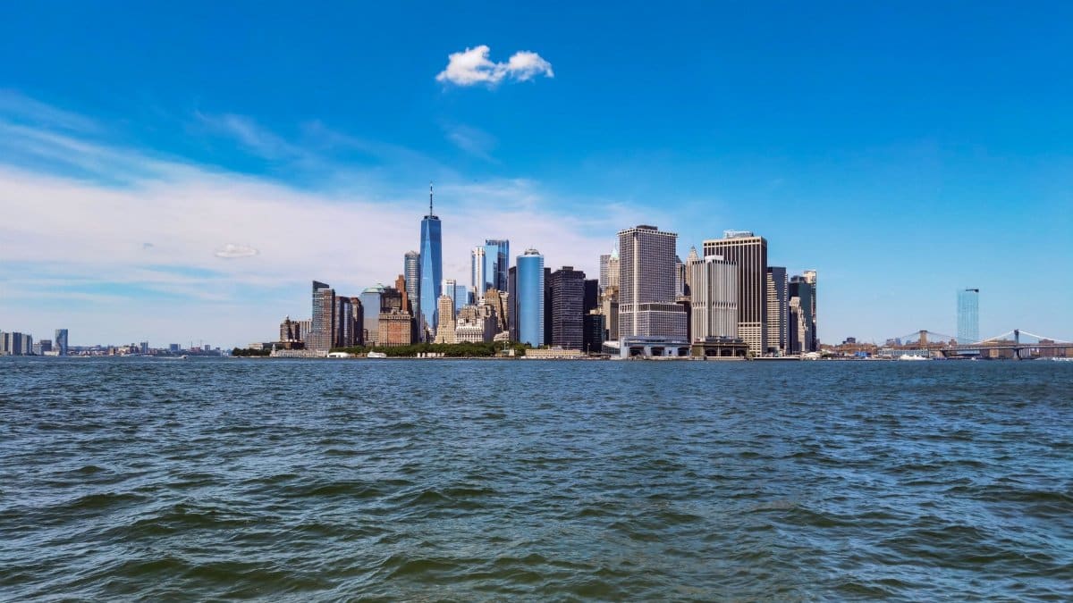 A stunning view of the New York City skyline featuring One World Trade Center across the Hudson River.