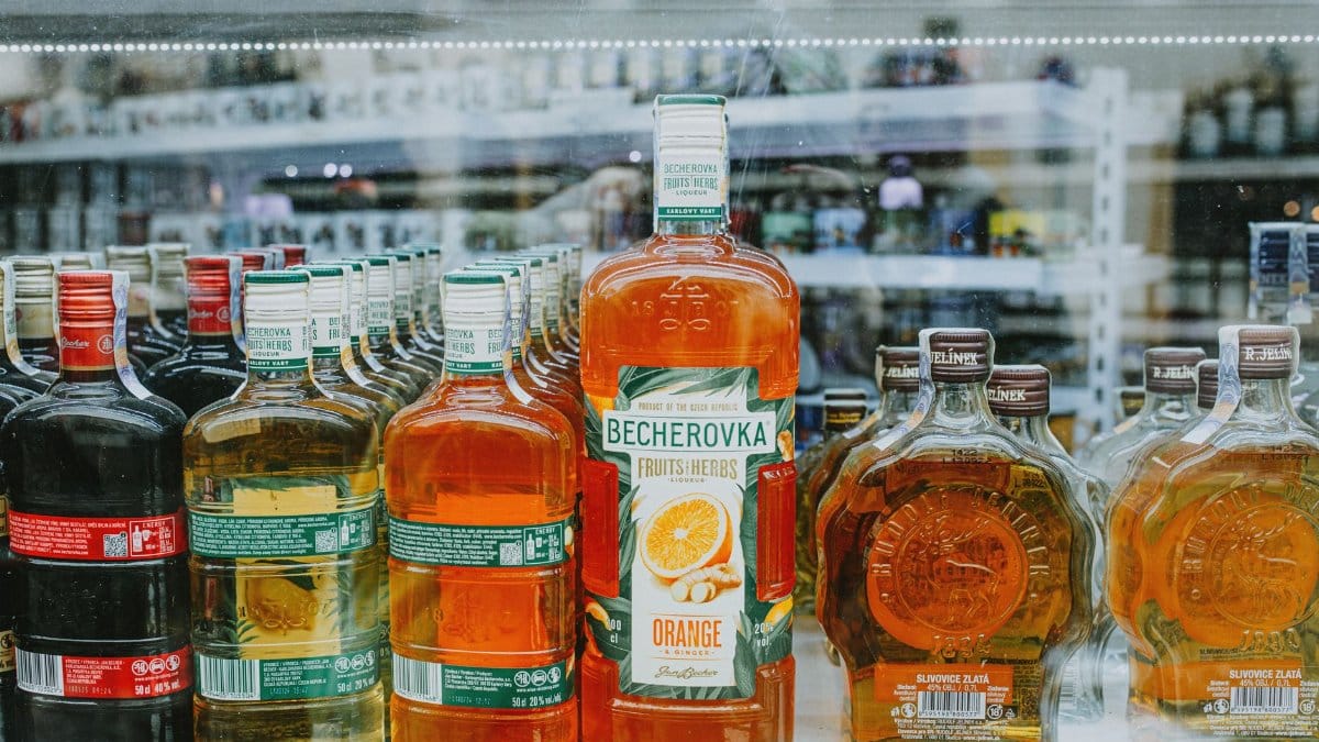 An array of vibrant liquor bottles displayed in a store showcase highlighting various spirits.